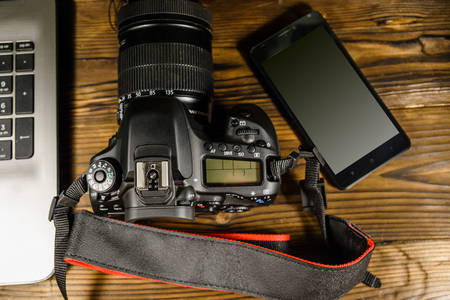 Aparat foto și smartphone pe masă de lemn